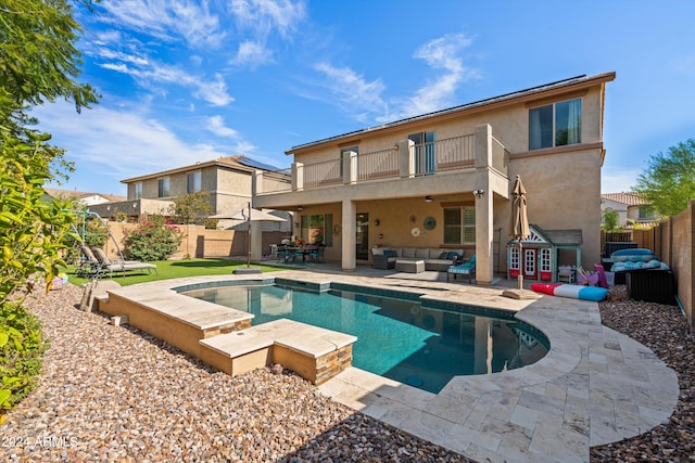 rear view of house with a patio, a balcony, a fenced backyard, outdoor lounge area, and stucco siding