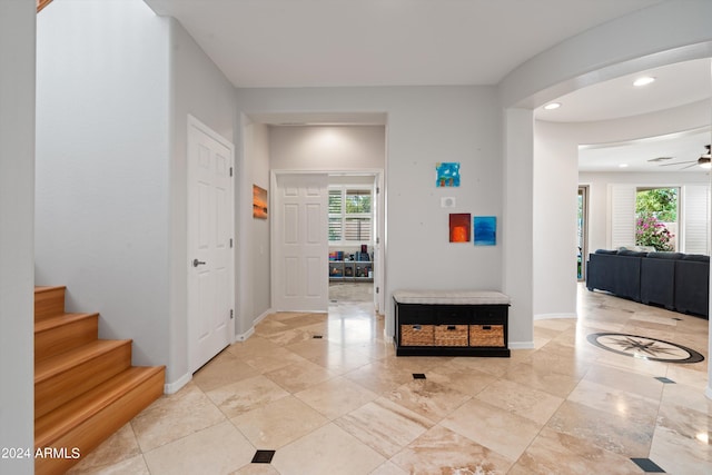 hall with baseboards, recessed lighting, stairs, and a healthy amount of sunlight