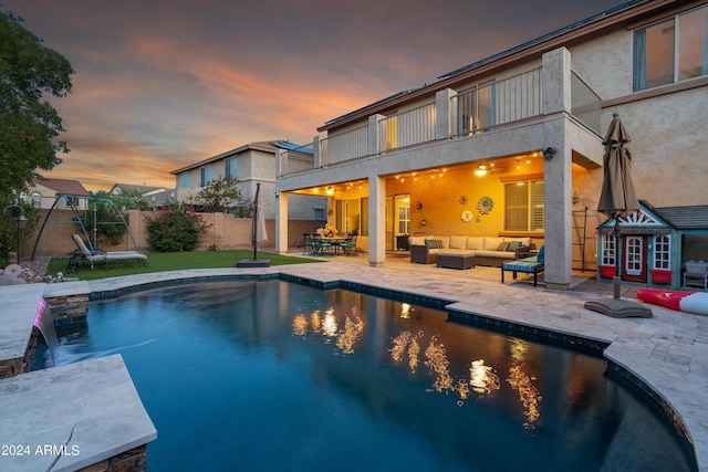 view of pool with fence, outdoor lounge area, a fenced in pool, and a patio