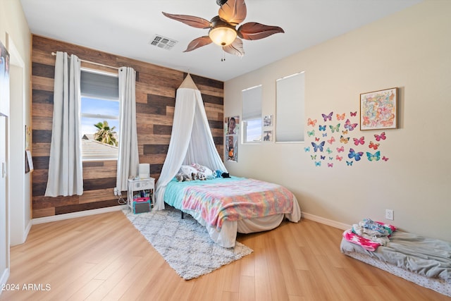 bedroom featuring visible vents, ceiling fan, baseboards, and wood finished floors