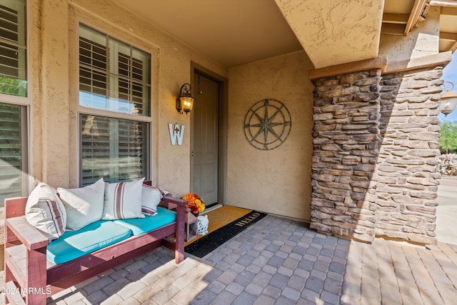 property entrance with stone siding and stucco siding