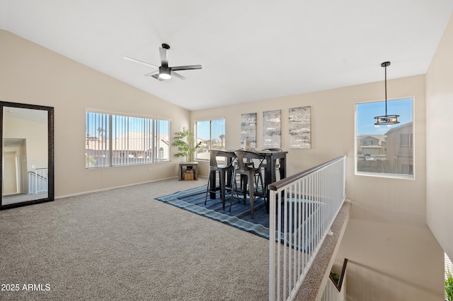 dining space with carpet flooring, ceiling fan, and vaulted ceiling