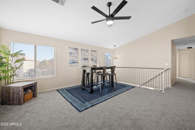 dining space with ceiling fan, carpet, and vaulted ceiling