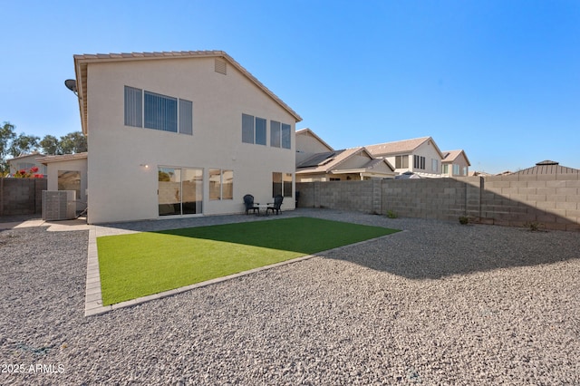 rear view of property featuring a patio, central AC, and a lawn