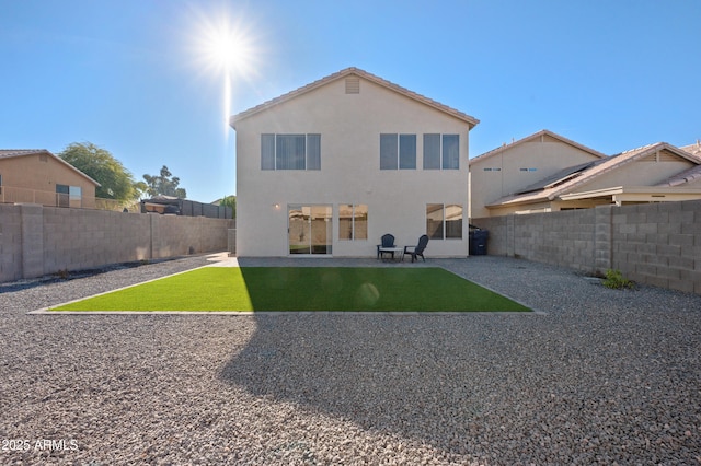 back of property with a yard and a patio