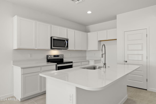 kitchen with white cabinets, appliances with stainless steel finishes, a kitchen island with sink, and sink