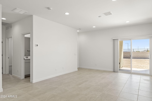 empty room featuring sink and light tile patterned floors