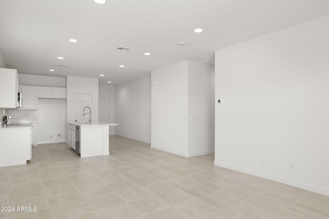 kitchen featuring a center island with sink, stainless steel dishwasher, white cabinets, and sink