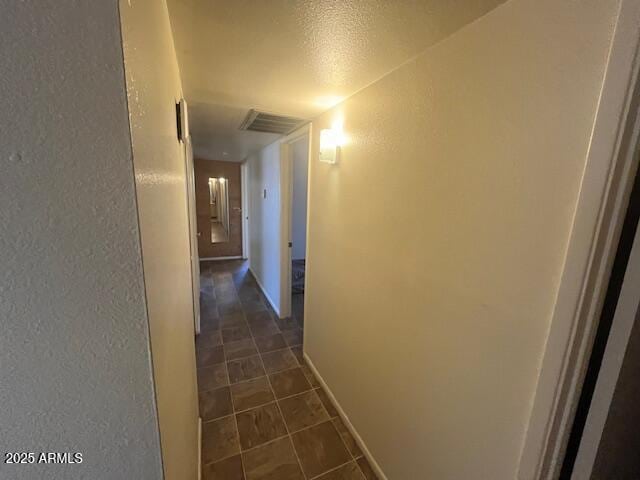 hall featuring dark tile patterned flooring