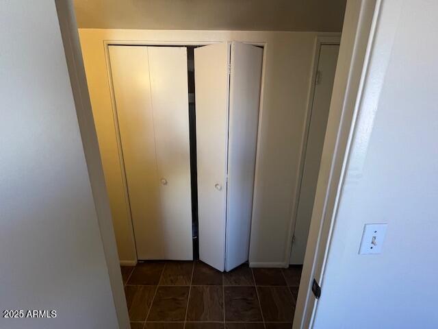 hall featuring dark tile patterned flooring