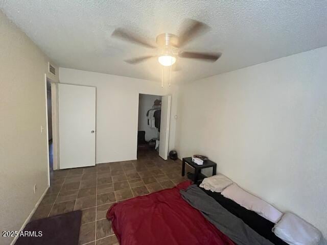 bedroom featuring ceiling fan and a textured ceiling