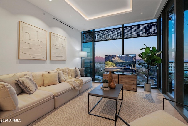 living room with a wall of windows and a tray ceiling