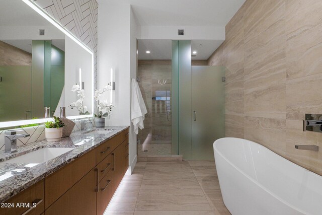 bathroom with vanity, tile walls, and shower with separate bathtub