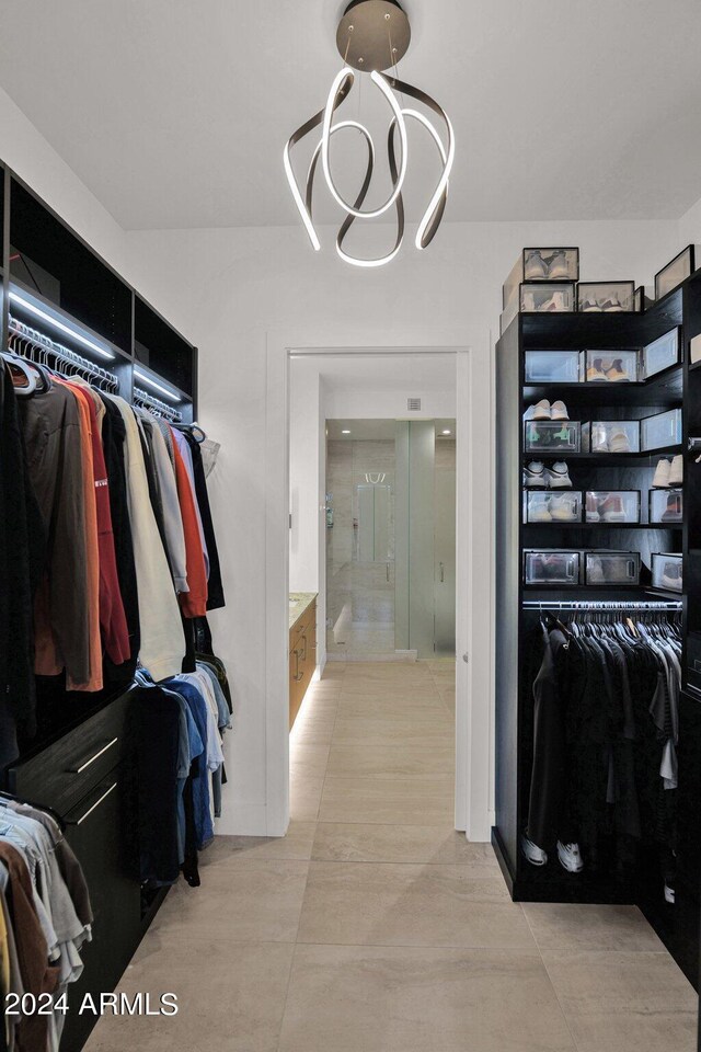 spacious closet featuring a notable chandelier