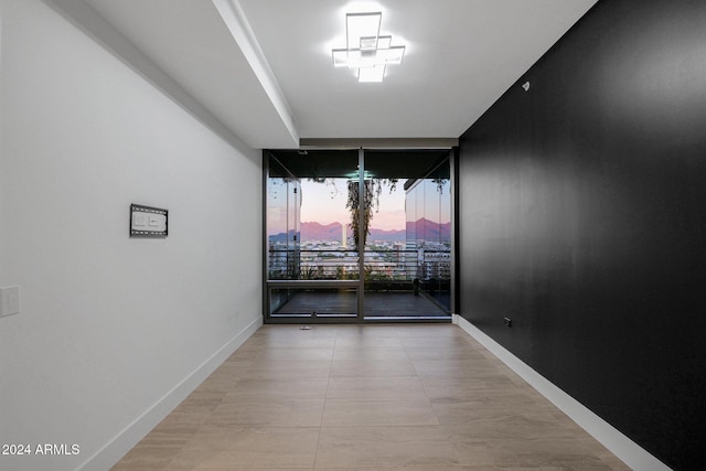 empty room featuring light tile patterned floors and floor to ceiling windows