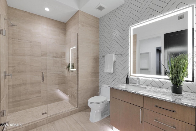 bathroom featuring walk in shower, vanity, toilet, and tile walls