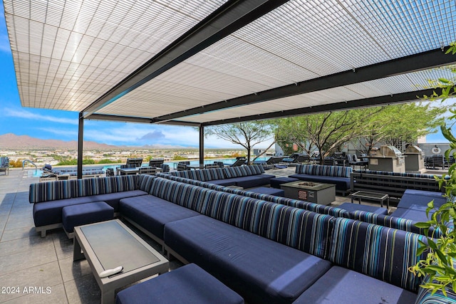 view of patio / terrace featuring a mountain view and an outdoor living space with a fire pit