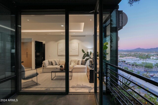 balcony at dusk featuring a mountain view and an outdoor hangout area