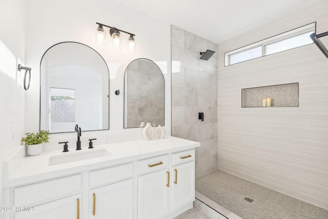 full bathroom featuring a healthy amount of sunlight, tiled shower, and vanity