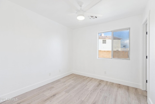 empty room featuring baseboards, ceiling fan, light wood-type flooring, and visible vents