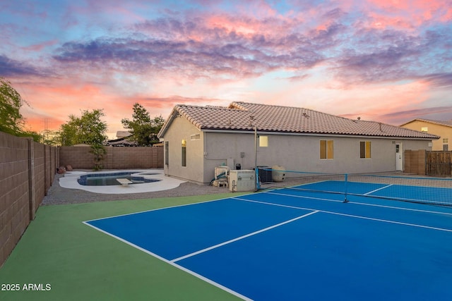 view of tennis court with a fenced in pool and a fenced backyard