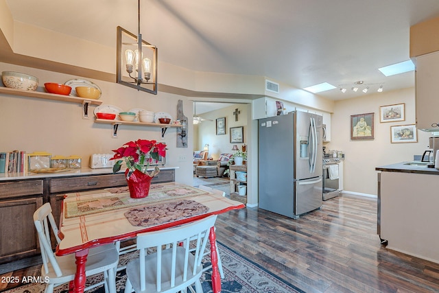 kitchen featuring a skylight, hanging light fixtures, dark hardwood / wood-style flooring, a notable chandelier, and appliances with stainless steel finishes