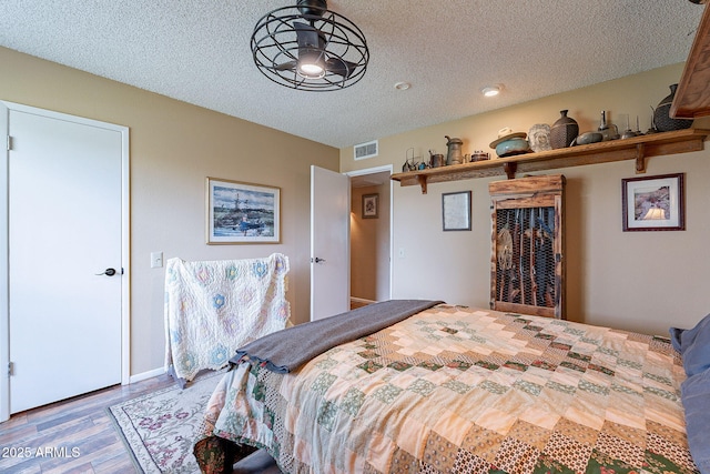 bedroom with hardwood / wood-style flooring and a textured ceiling