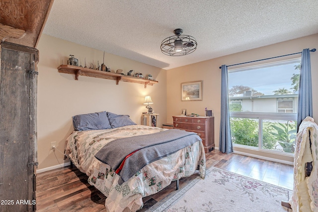 bedroom with a textured ceiling and dark wood-type flooring