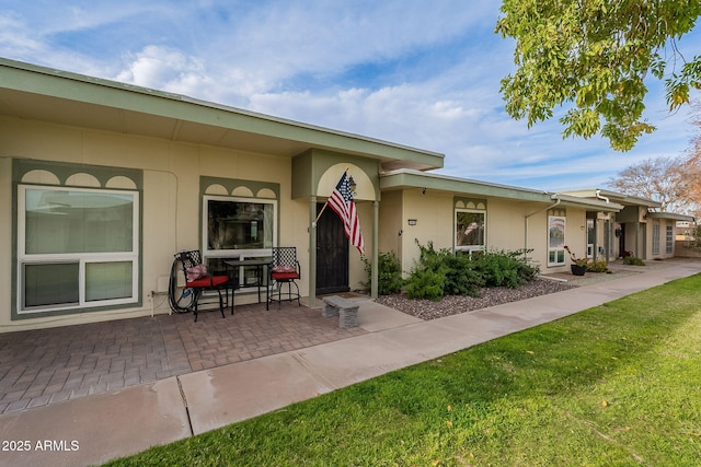 entrance to property with a yard and a patio