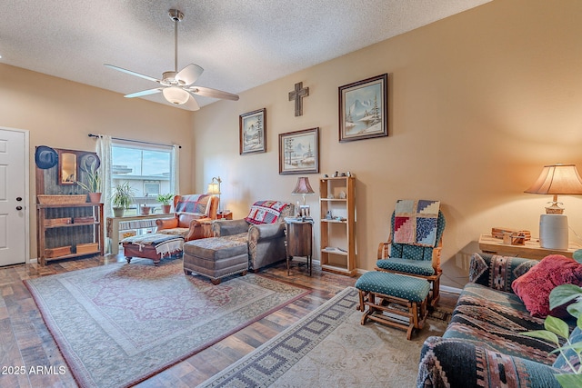 living room featuring ceiling fan, hardwood / wood-style floors, and a textured ceiling