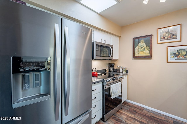 kitchen with white cabinets, stainless steel appliances, and dark wood-type flooring