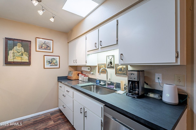 kitchen featuring white cabinets, sink, a skylight, stainless steel dishwasher, and dark hardwood / wood-style flooring