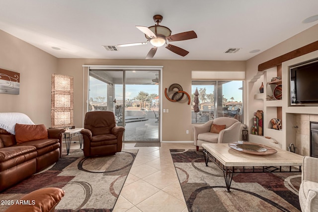 living room with light tile patterned floors, a fireplace, and ceiling fan