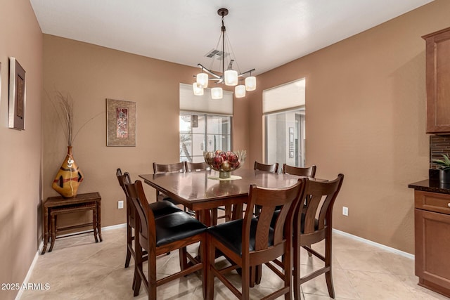 tiled dining area featuring a chandelier