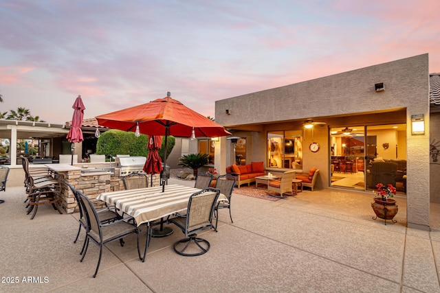 patio terrace at dusk featuring a bar, area for grilling, and outdoor lounge area