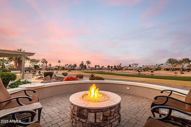 patio terrace at dusk featuring an outdoor fire pit