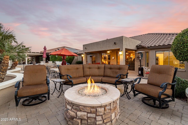 patio terrace at dusk featuring an outdoor living space with a fire pit