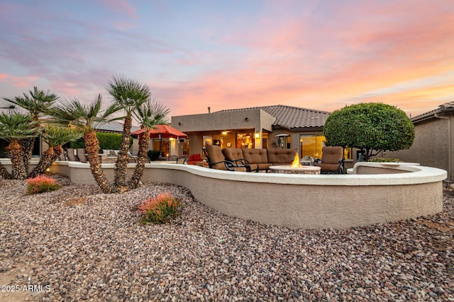 back house at dusk with a patio and an outdoor fire pit