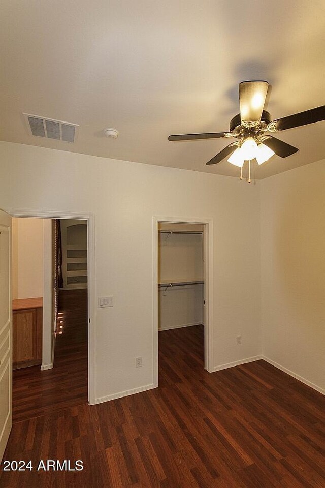 unfurnished bedroom featuring dark hardwood / wood-style flooring, a closet, and ceiling fan