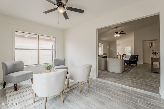 living area featuring ceiling fan, vaulted ceiling, and wood tiled floor