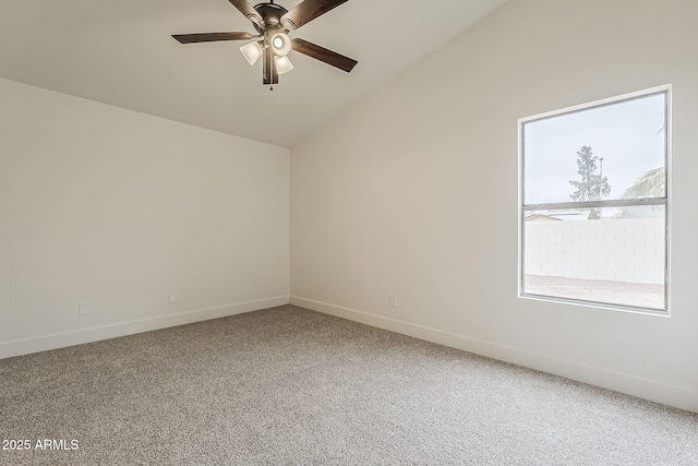 spare room featuring vaulted ceiling, baseboards, carpet floors, and ceiling fan