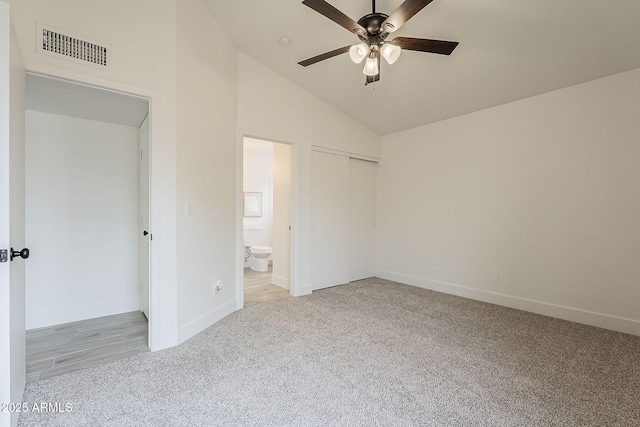 unfurnished bedroom with visible vents, baseboards, lofted ceiling, light carpet, and a closet