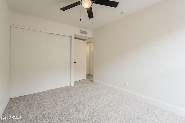 unfurnished bedroom featuring visible vents, a ceiling fan, a closet, baseboards, and light colored carpet