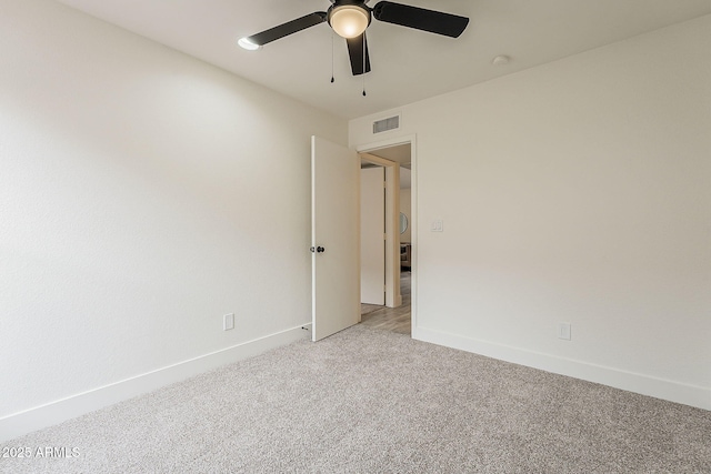 spare room featuring visible vents, baseboards, light colored carpet, and ceiling fan