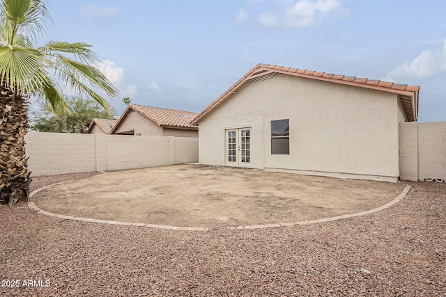 back of house featuring fence, stucco siding, french doors, a tile roof, and a patio area