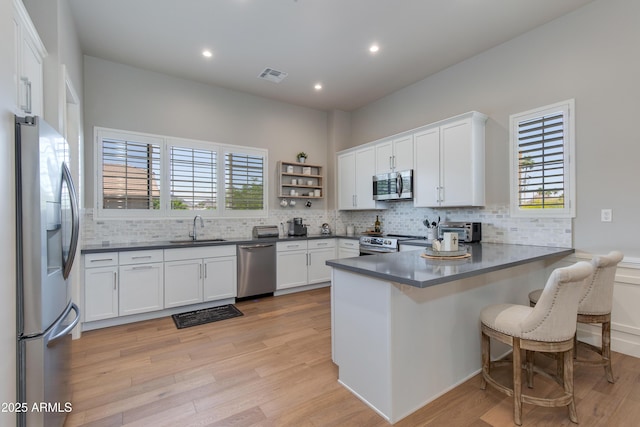 4438 N 27th St Unit 27, Phoenix, AZ 85016 - kitchen with appliances with stainless steel finishes, a sink, a peninsula, decorative backsplash, and dark countertops