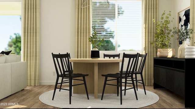 dining room with a wealth of natural light, baseboards, and wood finished floors