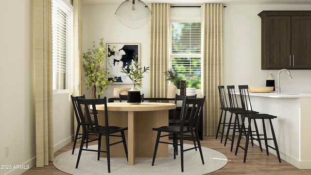 dining space featuring wood finished floors and baseboards