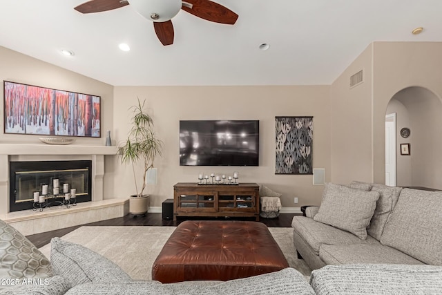 3733 E Kachina Dr, Phoenix, AZ 85044 - living area with arched walkways, baseboards, wood finished floors, a ceiling fan, and a glass covered fireplace