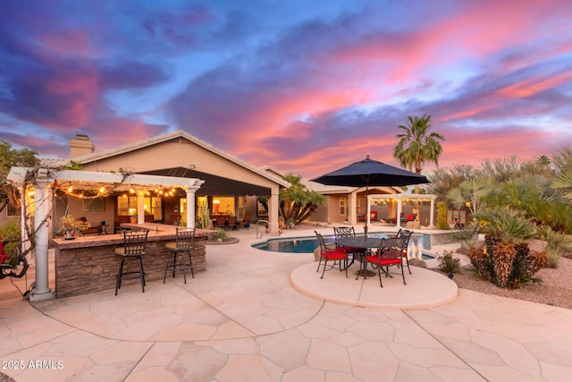 3733 E Kachina Dr, Phoenix, AZ 85044 - patio terrace at dusk featuring a patio, an outdoor pool, and a pergola
